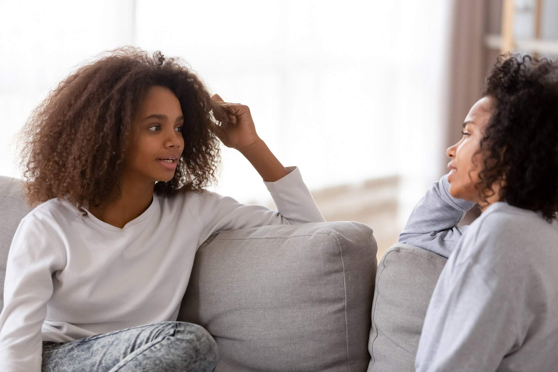 A menina encontra-se no sofá com o telefone. menina adolescente